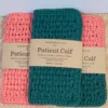 A set of three hand-crocheted washcloths in Tangerine and Forest Green with Patient Calf paper branding wraps.