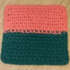 Hand-crocheted two-tone washcloth in Tangerine and Forest Green by Patient Calf, featuring a textured cotton stitch pattern.