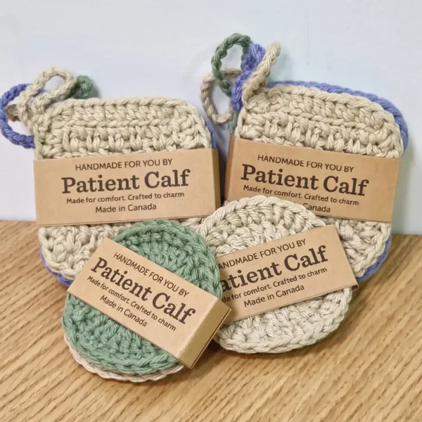 Close-up of Patient Calf handmade cotton scrubbies in square and round shapes, packaged with "Handmade For You" and "Made in Canada" brown paper bands.