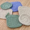 Close-up of Patient Calf handmade cotton scrubbies showing the textured crochet stitch in sage green, sand, and periwinkle-lilac colors across square and round shapes.