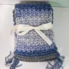 The Drina Scarf by Patient Calf folded and tied with a white ribbon bow, ready for gifting.