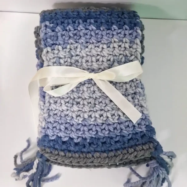The Drina Scarf by Patient Calf folded and tied with a white ribbon bow, ready for gifting.