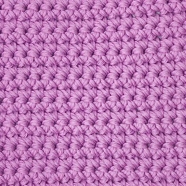 Extreme close-up of the solid Sweet Rose color cotton crochet texture on the Loire washcloth