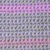 Extreme close-up of the nubby texture and shifting colors in the light sage, soft lilac and sweet rose Lorie washcloth