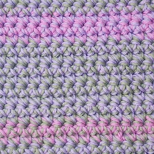 Extreme close-up of the nubby texture and shifting colors in the light sage, soft lilac and sweet rose Lorie washcloth