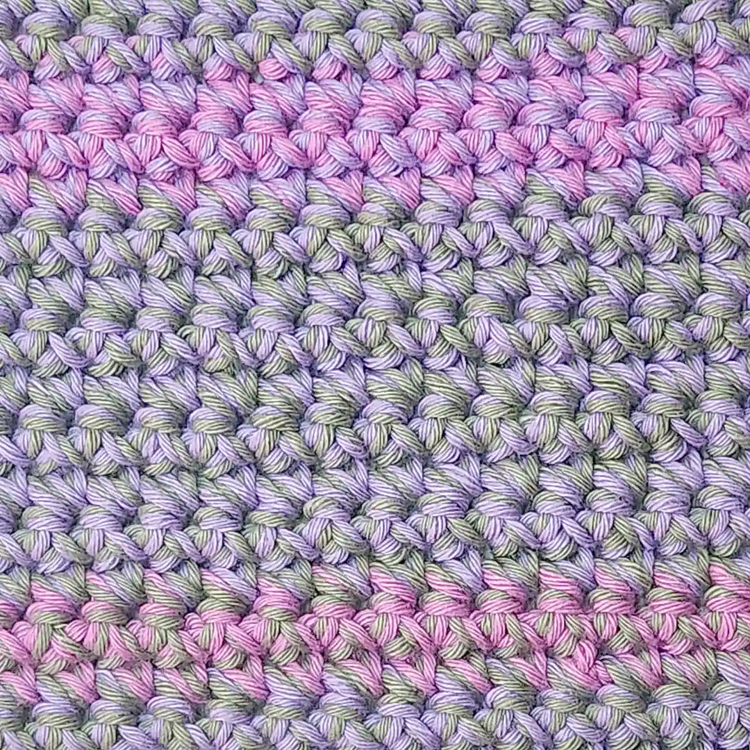 Extreme close-up of the nubby texture and shifting colors in the light sage, soft lilac and sweet rose Lorie washcloth
