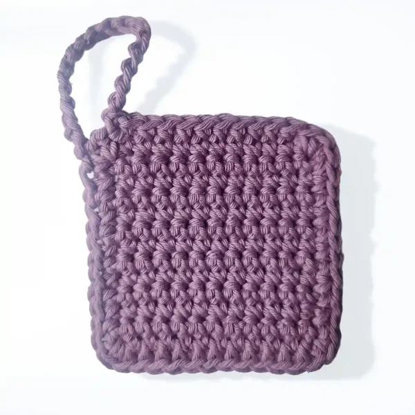 The Iris facial scrubbie by Patient Calf in Vintage Purple, showing the intricate, hand-crocheted nubby stitch.