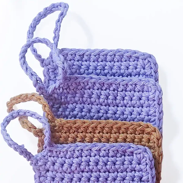 Three Iris scrubbies layered to show the neat square finish and sturdy hand-crocheted finger loops.