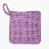 The Loire washcloth by Patient Calf in Sweet Rose and soft lilac, featuring a thick, cotton crochet texture and hanging loop.